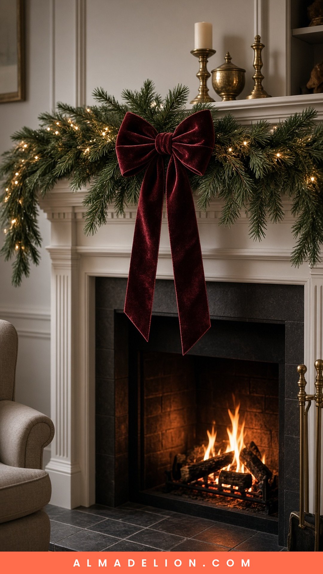 Oversized burgundy velvet bow hanging on an evergreen Christmas mantel garland